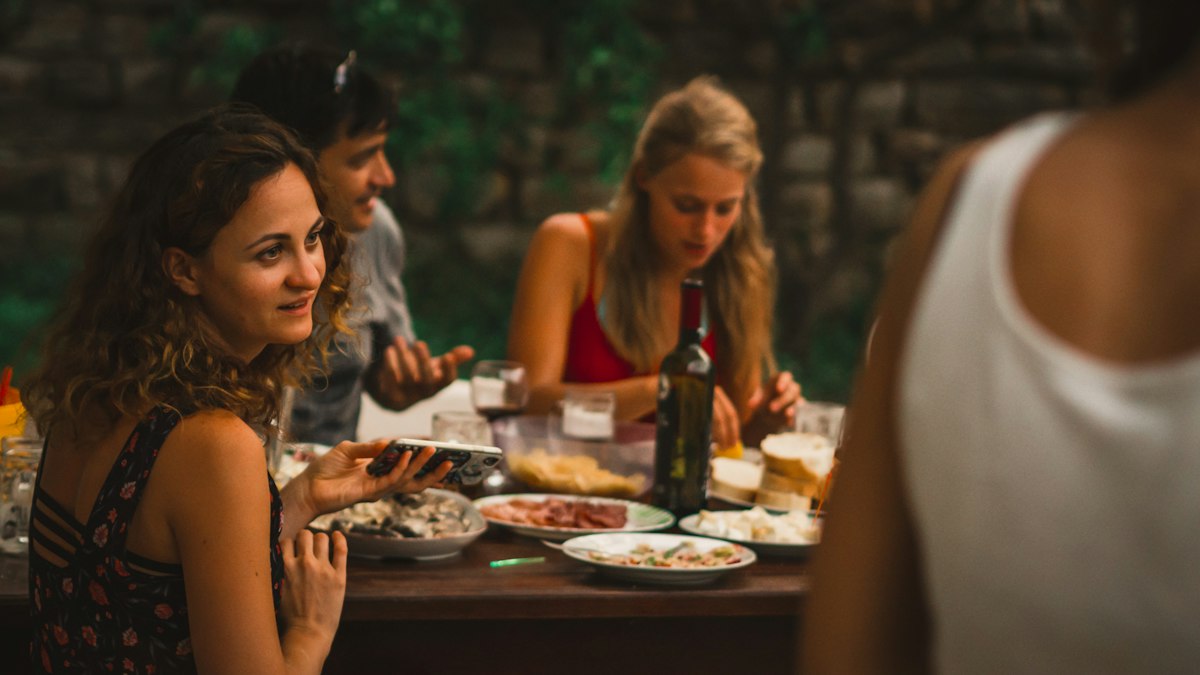 Freunde sitzen zusammen an einem gedeckten Tisch